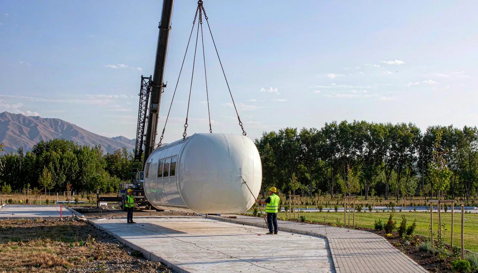 Crane lifting a capsule cabin onto its foundation